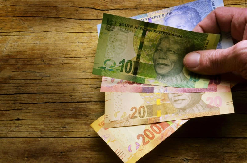 A person holding some Rand bills